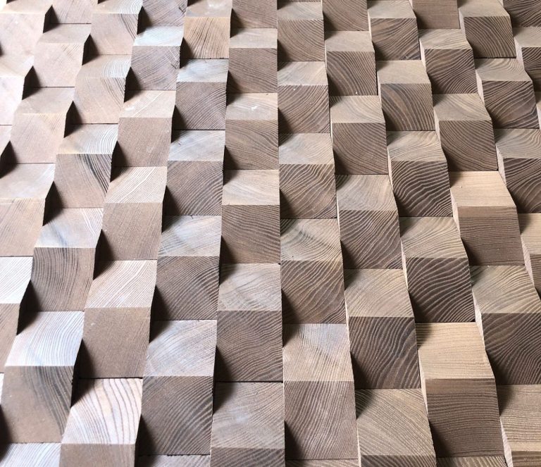 Eine große Menge an Holzklötzen ist nah beieinander gelegt. Man sieht die Muster und Schatten, die durch die Klötze generiert wurden.